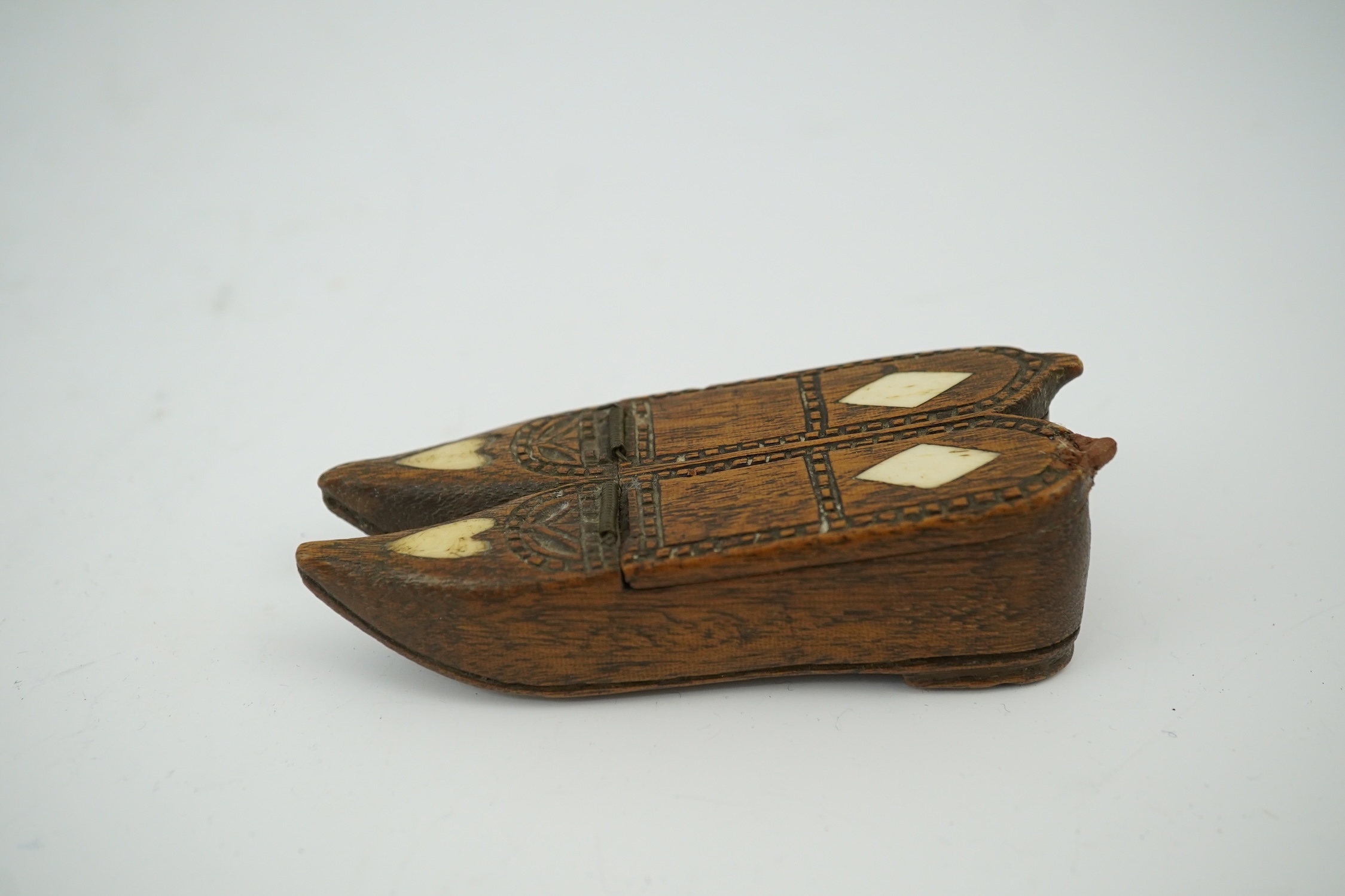 An early 19th century bone inset carved wood 'pair of shoes' snuff box with damaged sprung lid, 9.5cm long. Condition - good